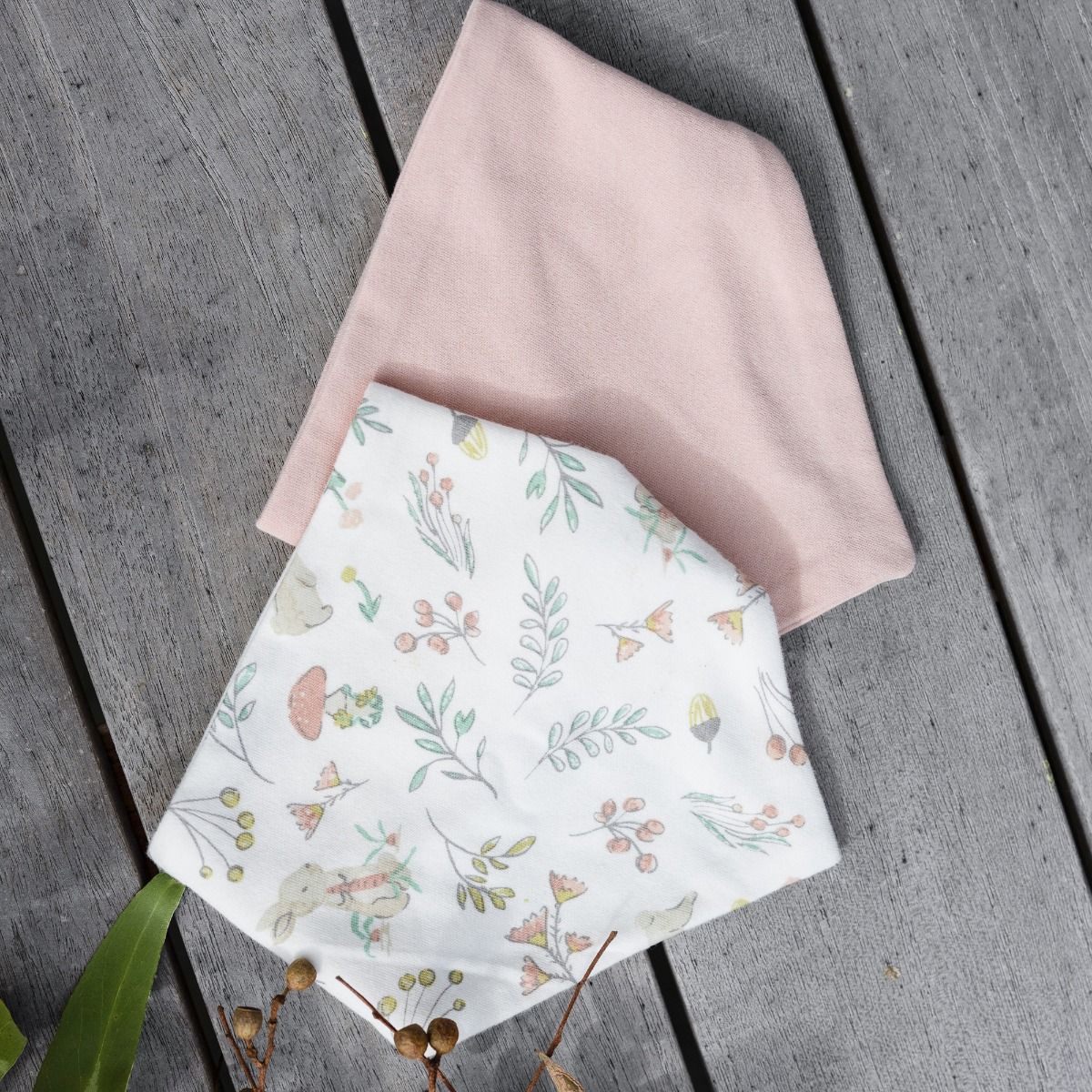 Floral-patterned and plan bib on a wooden surface