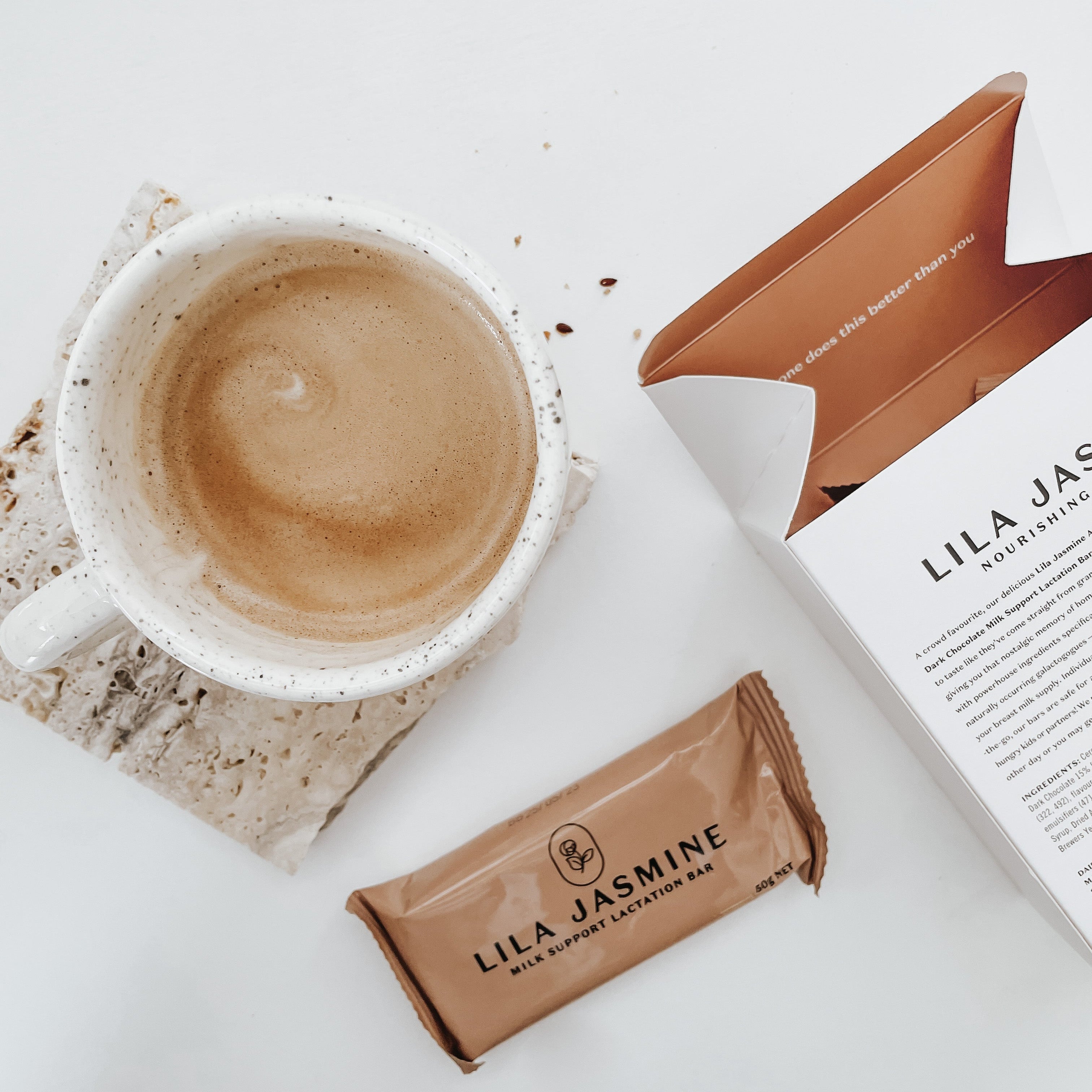 Cup of coffee with Lila Jasmine packaging on a white surface