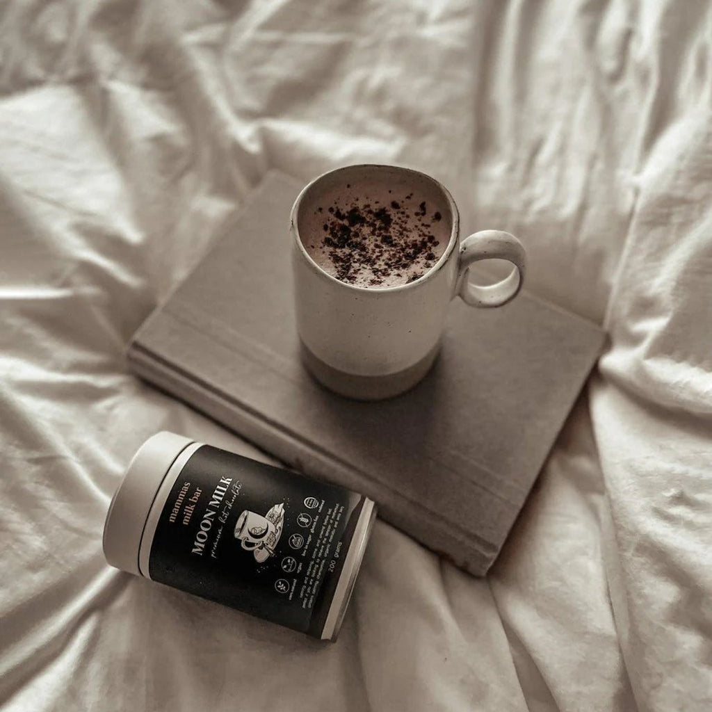 Cup of coffee with a book and coffee can on a bed