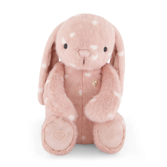 Pink plush bunny toy with white polka dots on a white background