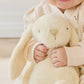 Child holding a plush bunny toy in a cozy setting