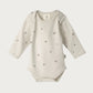 Beige baby bodysuit with star patterns on a white background
