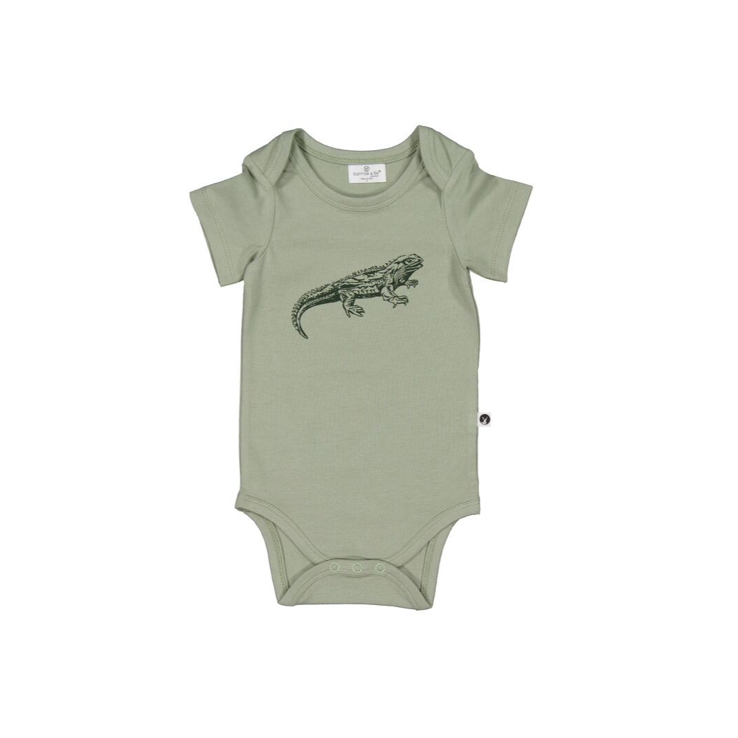 Green baby onesie with a tuatara design on a white background