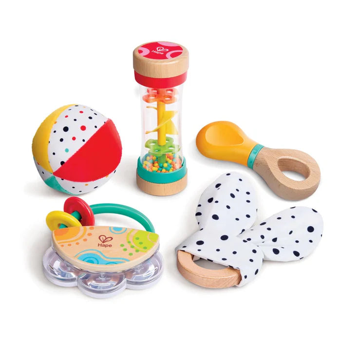 Set of colorful baby toys including a ball, rattle, and teether on a white background