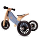 Children's balance bike with wooden frame and blue seat on a white background