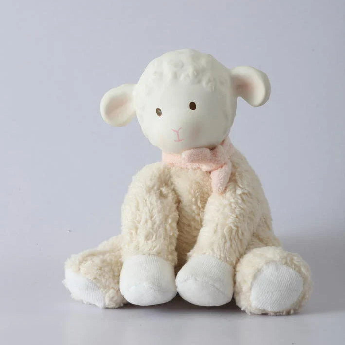 Stuffed sheep toy with a pink bow on a light gray background