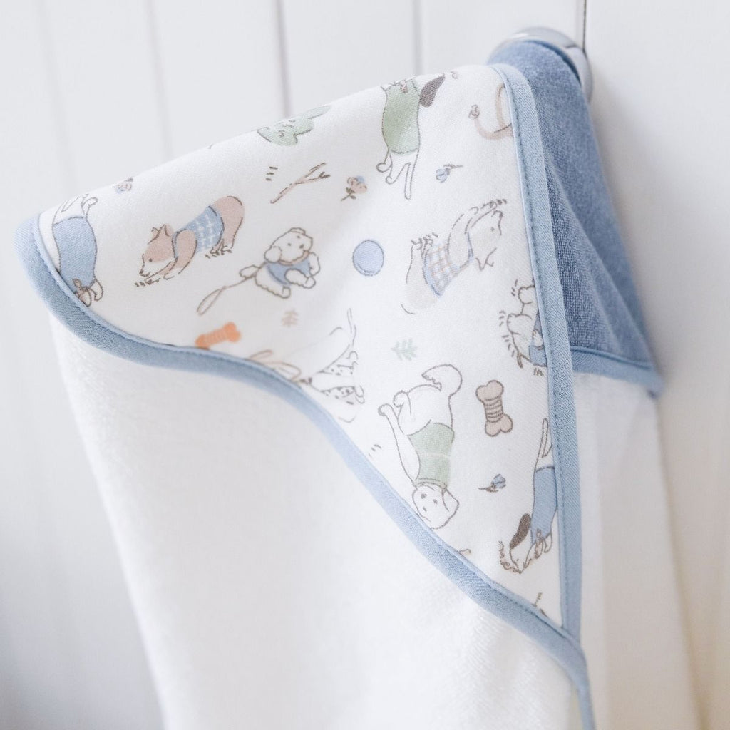 Baby hooded towel with dogs pattern hanging on a door knob