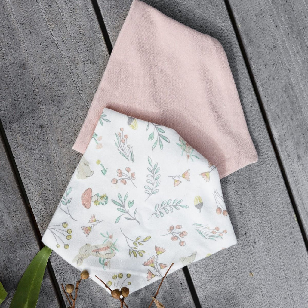 Floral-patterned and plan bib on a wooden surface