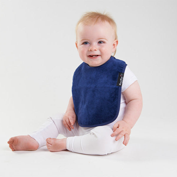 Baby wearing a blue bib on a white background