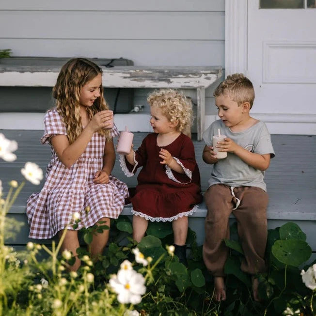 children enjoying norish wholefoods smoothie blend outside on verandah