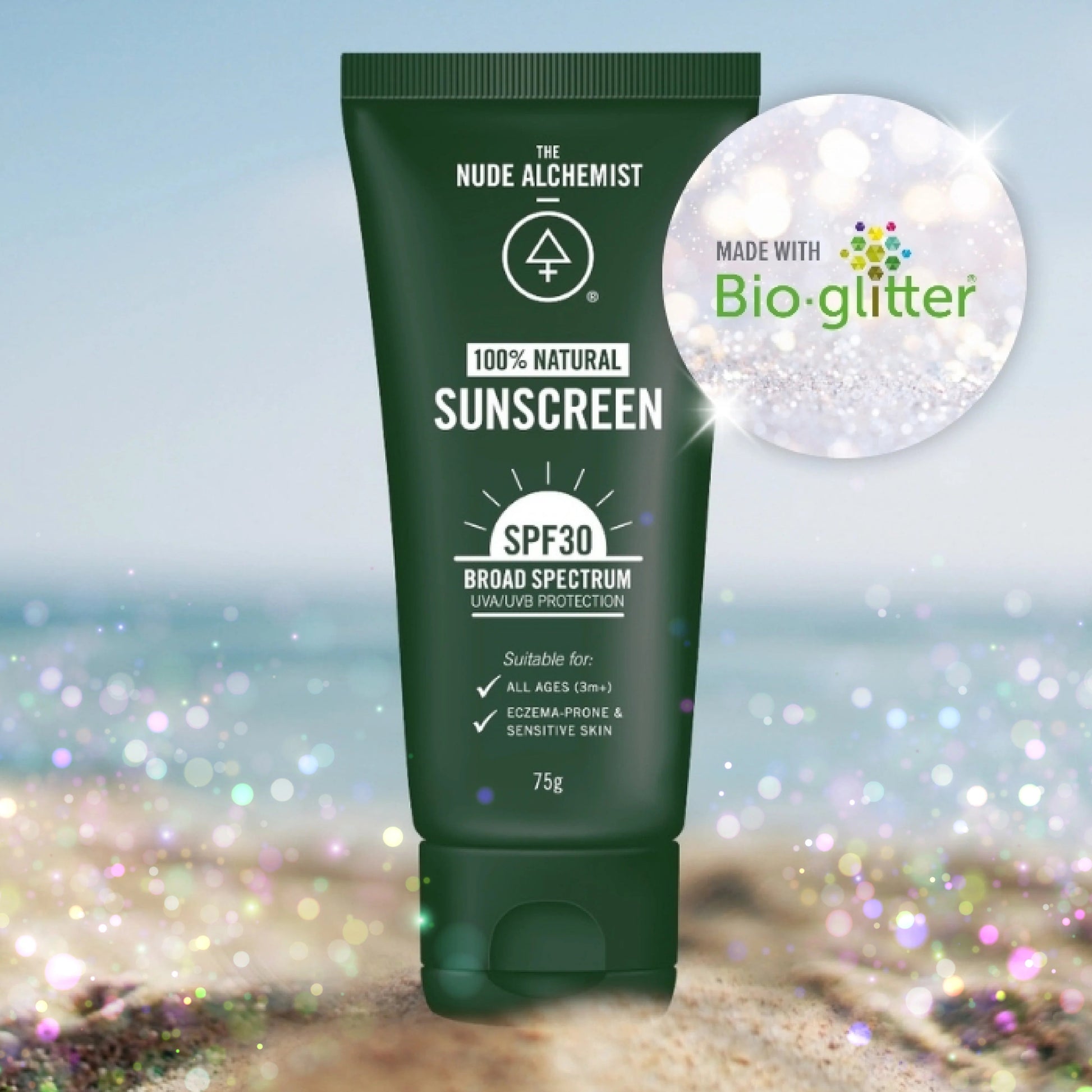 Green sunscreen tube with 'The Nude Alchemist' branding on a beach background