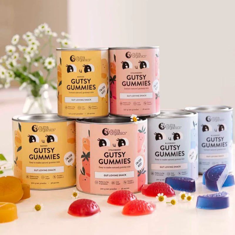 Assorted cans of Gutsy Gummies on a light background with gummy bears.