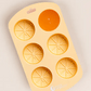 Silicone mould with orange shapes on a beige background
