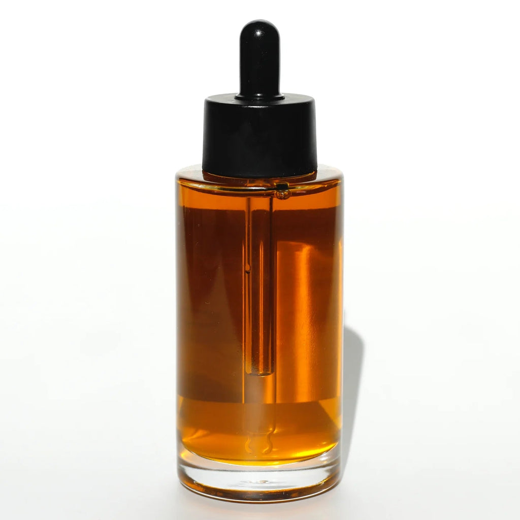 Glass dropper bottle with amber liquid on a white background