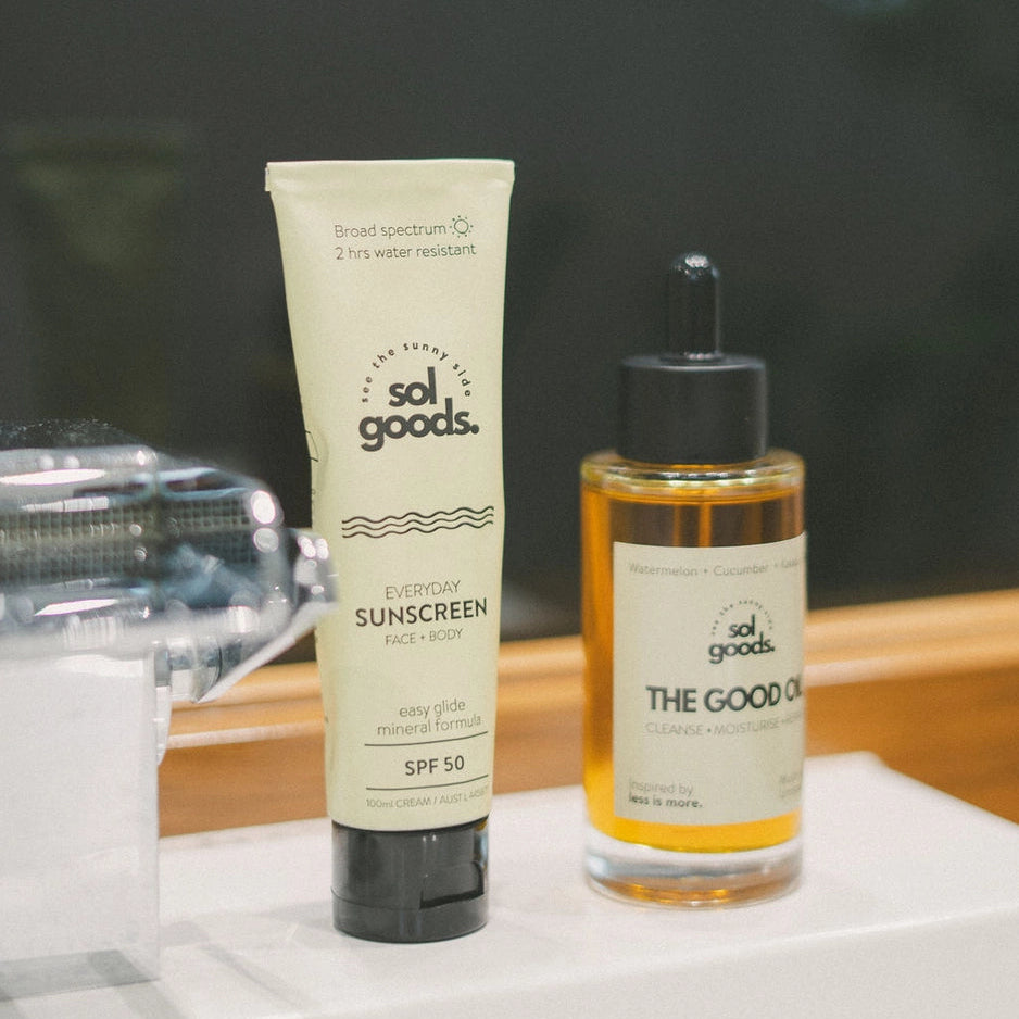 Two skincare products from sol goods on a white surface with a blurred background